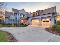 Charming two-story home featuring a two-car garage, inviting front porch, and beautiful blue siding at 1857 W Canning Dr, Mount Pleasant, SC 29466