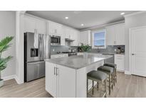 Bright kitchen features stainless steel appliances, island with seating, and white cabinets at 202 Garden Gate Way, Summerville, SC 29486