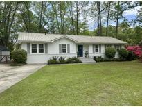 Charming single-story home boasts a well-manicured lawn, fresh landscaping, and an inviting blue front door at 640 Semaht St, Charleston, SC 29412