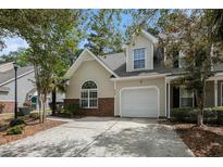 Charming home featuring a one-car garage, well-maintained lawn, and beautiful landscaping at 8739 Grassy Oak Trl, North Charleston, SC 29420