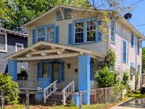 Charming two-story home with light siding, blue shutters, and inviting front porch at 15 Poplar St, Charleston, SC 29403