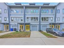 Modern townhome with light-blue siding, gray trim, yellow doors, and single-car garages at 1816 Orangeburg St, North Charleston, SC 29405