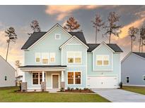 Charming two-story home featuring light blue siding, a welcoming front porch, and an attached two-car garage at 1824 Nola Run, Summerville, SC 29485