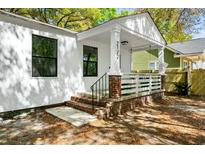 Inviting front porch with brick accents, fresh white paint, and classic architectural details at 2122 Commander Rd, North Charleston, SC 29405