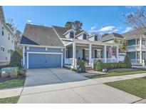 Charming blue two-story home with inviting front porch, attached garage, and well-manicured landscaping at 3697 Stamler Ct, Mount Pleasant, SC 29466