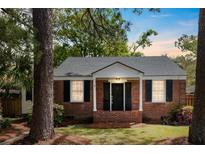 Charming brick home with black shutters and a manicured lawn at 1 Colleton Dr, Charleston, SC 29407