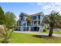 Charming blue two-story home with well-manicured lawn, stairs, and lush greenery offering curb appeal at 1188 Quick Rabbit Loop, Charleston, SC 29414
