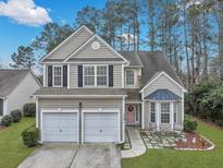 Charming two-story home featuring a two-car garage, front garden, and a welcoming pink front door at 2004 Hammond Dr, Mount Pleasant, SC 29466