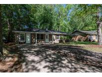 Charming single-story home featuring a brick facade, complemented by lush trees and a lengthy private driveway at 203 Elliott Dr, Ladson, SC 29456