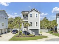 Charming gray home featuring a two-story porch, manicured lawn, and private driveway at 2928 Tranquility Rd, Mount Pleasant, SC 29466