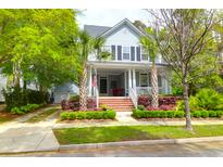 Charming home with a welcoming front porch, palm trees, and lush landscaping at 3030 Baltimore St, Charleston, SC 29492