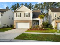 Charming two-story home with a brick-accented facade, well-manicured lawn, and a two-car garage at 332 Long Pier St, Summerville, SC 29486