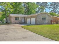 Charming brick home with a well-maintained lawn and a two-car garage at 100 Lipman St, Summerville, SC 29483