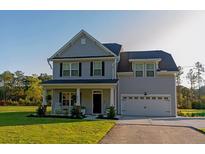 Charming two-story home with a well-maintained lawn and two car garage at 10032 Randall, McClellanville, SC 29458