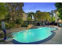 Backyard pool featuring a rock waterfall and sun loungers for a relaxing outdoor experience at 101 Writing Ct, Ladson, SC 29456