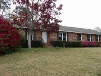 Charming brick home with a well-maintained lawn and blossoming azalea bushes at 136 Tall Pines Rd, Ladson, SC 29456
