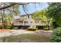 Charming two-story home with a spacious porch, lush landscaping, and ground level parking at 1651 Atlantic Ave, Sullivans Island, SC 29482