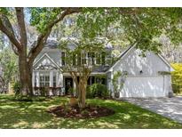 Charming two-story home with a well-manicured lawn and mature trees, offering great curb appeal at 1920 Oak Tree Ln, Mount Pleasant, SC 29464