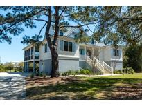 Charming home with a raised foundation, elevated screened porch, and a staircase leading to the front door at 2312 Rushland Landing Rd, Johns Island, SC 29455