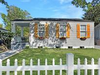 Charming home featuring three windows with stylish shutters, complemented by a white picket fence and a well-manicured lawn at 2313 Kent Ave, North Charleston, SC 29405