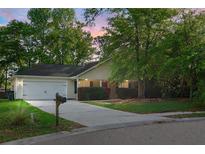 Charming single-story home with a well-maintained lawn, mature trees, and a two-car garage at 301 Huntington Ct, Hanahan, SC 29410