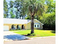 Charming brick home with lush front yard and mature palm tree for shaded curb appeal at 307 Fairington Dr, Summerville, SC 29485