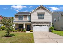 Charming two-story home with stone accents, a well-manicured lawn, and a two-car garage at 364 Deep River Rd, Summerville, SC 29486
