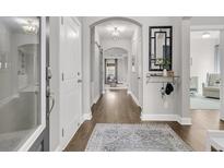 Inviting hallway features wood floors, neutral walls, and arched entryway to an open-concept living space at 3968 Hanoverian Dr, Mount Pleasant, SC 29429
