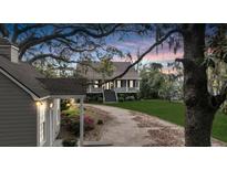 Charming two-story home featuring a picturesque wrap-around porch and a long, winding driveway through a lush, landscaped yard at 4584 Olde Smoak House Rd, Meggett, SC 29449