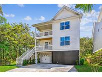 Stunning three-story home with double balconies and stairway leading to the ground level at 5035 Gum Tree Ln, Johns Island, SC 29455