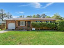 Charming single-story brick home with a well-maintained lawn and manicured bushes at 65 University Dr, Ladson, SC 29456