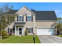 Charming two-story home featuring a well-manicured lawn, attached garage, and classic black shutters at 712 Bent Hickory Rd, Charleston, SC 29414