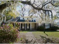Charming brick home featuring a covered porch, dormer windows, and a well-manicured front yard at 731 Pitt St, Mount Pleasant, SC 29464