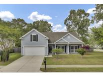 Charming single-Gathering home featuring a well-manicured lawn, attached garage, and beautiful landscaping at 8001 Hydrangea Ln, Hanahan, SC 29410
