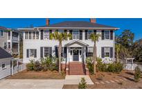 Charming two-story traditional home with white siding, black shutters, palm trees, and a welcoming front entrance at 1075 Avenue Of Oaks, Charleston, SC 29407