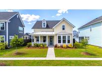 Charming two-story home with a inviting front porch, colorful landscaping, and well maintained lawn at 113 Grimball St, Summerville, SC 29486