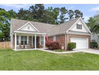 Charming brick home with a well-manicured lawn, attached garage, and inviting front porch at 117 Back Tee Cir, Summerville, SC 29485