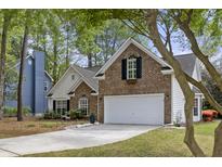 Charming two-story home with a brick facade, white garage door, and well-manicured landscaping in a lush, green setting at 1177 Old Ivy Way, Mount Pleasant, SC 29466