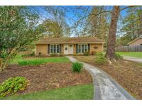 Charming single story home featuring manicured lawn, brick facade, and inviting stone walkway at 123 Tiffany Ln, Summerville, SC 29485