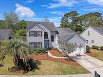 Charming two-story home with basketball hoop, landscaped yard, and a welcoming walkway to the front door at 1310 Belhaven Dr, Mount Pleasant, SC 29466