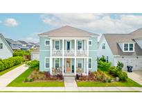 Charming two-story home with a welcoming double porch, adorned with chairs and a peach-colored front door at 144 Sandy Bend Ln, Summerville, SC 29486