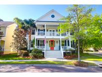 Charming two-story home with double front porches, red front door and beautifully landscaped yard at 147 Musket Loop, Summerville, SC 29483