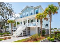 Charming coastal home with light blue siding, white trim, and inviting front porch with palm trees at 1537 Cultivation Ln, Mount Pleasant, SC 29466