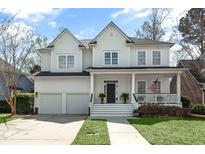Charming two-story home featuring a welcoming front porch, manicured lawn, and attached two-car garage at 1749 James Basford Pl, Mount Pleasant, SC 29466