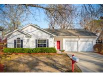 Charming single-story home featuring a red front door, attached garage, and well-maintained landscaping at 1906 Cedar Petal Ln, Charleston, SC 29414