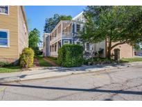 Charming two-story home features a spacious porch and landscaped yard with mature trees at 22 Ashton St, Charleston, SC 29403