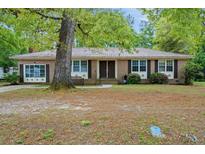 Charming brick home featuring a double-door entry and a covered front porch swing at 223 Dandridge Rd, Walterboro, SC 29488