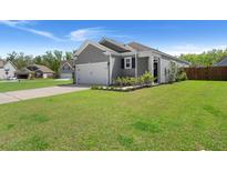 Charming home with a well-manicured lawn, gray siding, and an attached two-car garage at 223 Goshen Rd, Moncks Corner, SC 29461