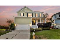 Charming two-story home with a welcoming front porch, manicured lawn, and attached two-car garage at 2242 Terrabrook Ln, Charleston, SC 29412
