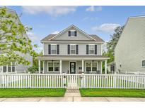 Charming two-story home with a welcoming front porch and a white picket fence at 227 Oak View Way, Summerville, SC 29483